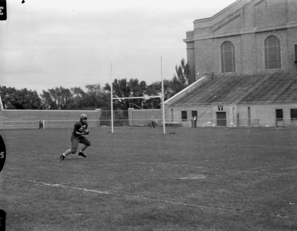 Jerry Witt, halfback on the University of Wisconsin football team, catching a pass leading to a touchdown in the annual university spring football game of the Cardinals vs. the Whites.