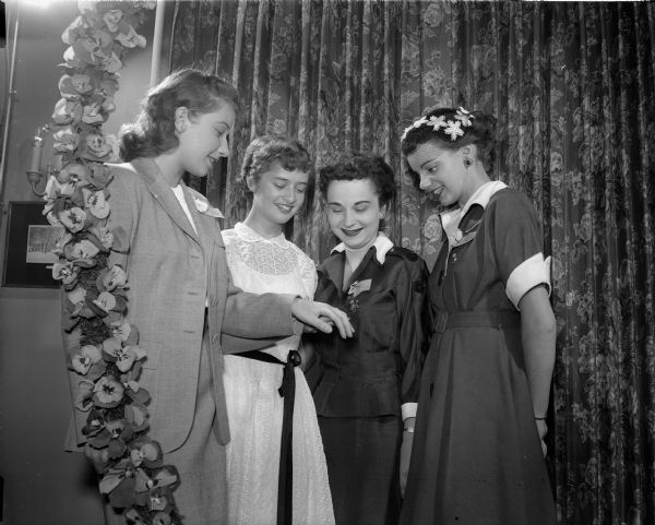 Four women at the Tri Delta "Pansy Breakfast," during which the sorority honors engaged and "pinned" women. At left Trudy Vornberger, Wauwatosa, is showing her engagement ring to, left to right, Renee L'Hommedieu, Jane Hasselman and Carla Kolb.