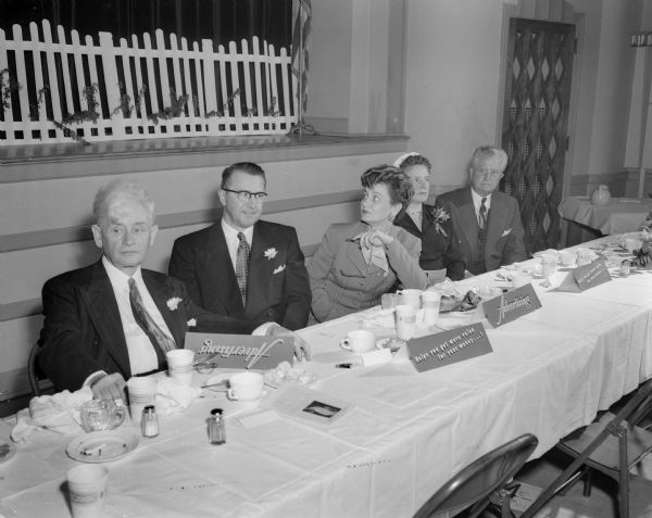 Left to right at the head table of the Madison Advertising Club Bosses' dinner are: Ralph O'Connor, WISC manager and club president; Burton Bigelow, sales expert and lecturer; J.A McIlnay; Mrs. Bigelow; Mrs. (Pearl) McIlnay; Dean F.H. Elwell, University of Wisconsin school of commerce; and John Reese, program chairman.