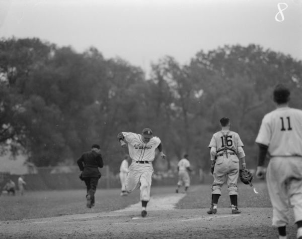 Wisconsin's Ted Baumgarten crosses home plate with the tying run in a baseball game against the University of Michigan at Lowman field.
