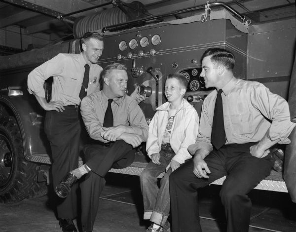 Members of the Madison Firefighters union, Local 311, chose twelve-year-old Dick Hanson, son of Mr. and Mrs. Adrian (Inez) Hanson, 134 South Butler Street (second from right), as their entry. Left to right are: firefighters Lyle Mepham, Arne Moen, Dick, and Don Simon.
