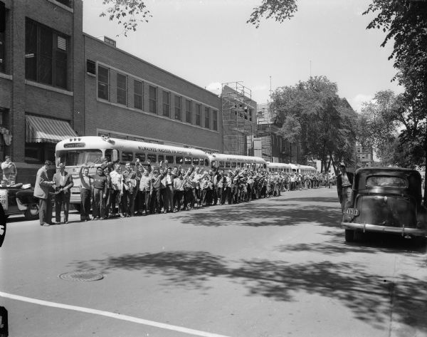 One hundred eighteen newspaper carrier boys ready to board four buses in front of the Madison Newspaper building on Carroll Street for a trip to Indianapolis and Chicago to see the auto race and a major league baseball game.