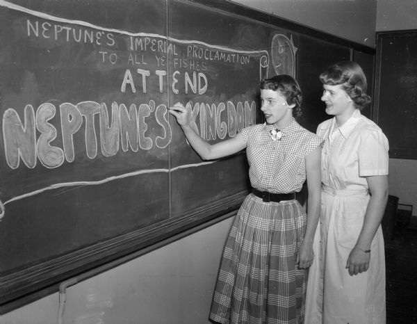 Dorothy Bell, at left, and Karen Center, at right, finish a sign advertising "Neptune's Kingdom," the dance West High school juniors are planning to honor graduating seniors. Both girls are members of the planning committee for the dance.