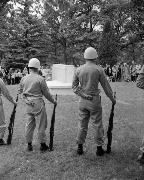 Two members of the Oregon Veterans of Foreign Wars drill team and some of the crowd gathered at Forest Hill Cemetery during services to dedicate a marble monument to the memory of the dead of the Spanish-American War and World Wars I and II.