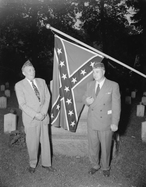 Two veterans with a confederate flag in front of Confederate Rest in  Forest Hill Cemetery during Madison's Memorial Day ceremonies.