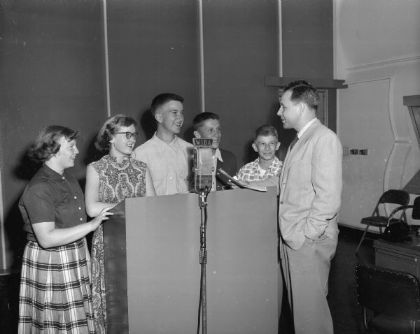 William J. Kimball, Dane County 4-H Club agent, works with the top winners of the junior and senior speaking contests to prepare for a radio presentation to be broadcast over radion station WIBA. From the left are: Carmen Haley, McFarland; Peggy Coons, Route 2, Mt. Horeb; Winston Collins, Route 2, Mt. Horeb; Richard Wigglesworth, Route 1, Dane; and Dale Zentner, Middleton.