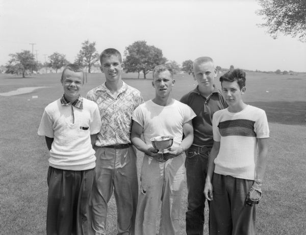 Group portrait of the five low scorers at the city Junior Chamber of Commerce golf tournament at the Monona course. Left to right are Jacky Allen, Rollo Vallem, Gordy Ledford holding the trophy, Lowell Bakken, and Carl Fritz.