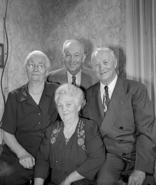 Group portrait of four siblings of the Henry W. Vogts Sr. family. Seated at center is Mrs. Dora Olhagen of Hanover, Germany. At left is her sister, Mrs. Emma Schwenn of Waunakee. Behind her is brother Fred Vogts, and at right is brother Henry W. Vogts, Jr., both of Madison. They celebrated being reunited with Dora after being separated for more than 58 years.