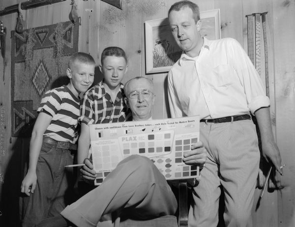 Two men from C.C. Collins and Sons, Inc. look over a color chart for their racers with two boys they are sponsoring in the soap box derby race. Left to right are racers Tommy Trimble and Mike Welch, and Robert J. Connor and Robert J. Connor, Jr. of the sponsoring company.