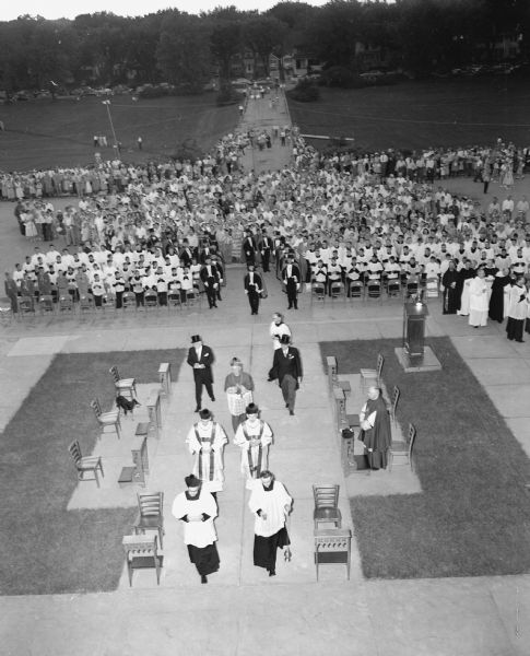 Overhead shot of celebrants, procession of priests, and gathered laity at a Holy Hour of Prayer for the "peace and liberation of the prisoners of the faith" in faraway lands.  The evening service was held at Edgewood College on Sunday, June 29, 1952.