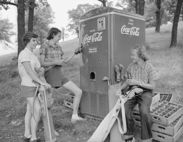 Three girls stopped at the soda vending machine during the first junior day at Blackhawk Country Club. Left to right are Connie Zeitner, Betty Blue, and Barbara Dettloff.
