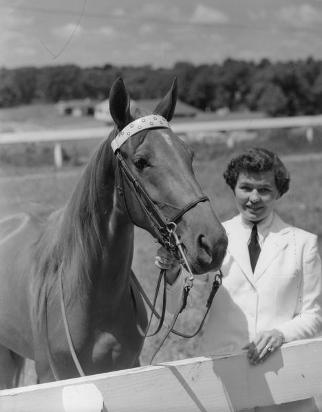 Bette Dolva standing outdoors at a fence with the horse "Yvonne's Stonewall Star."