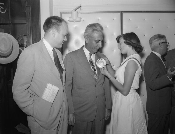 Mrs. Roland C. Ellis pins a Wisconsin button on attorney Fred Risser of Madison at the Republican National Convention in Chicago. Looking on at left is State Senator Melvin R. Laird of Marshfield.