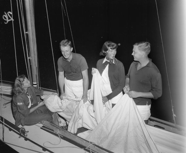 Two couples use a sailboat near the Edgewater Hotel pier during the Mendota Yacht Club moonlight regatta and picnic supper. They are Edmund and Marianne Hobbins, left, and Perry and Patricia Neff. 

