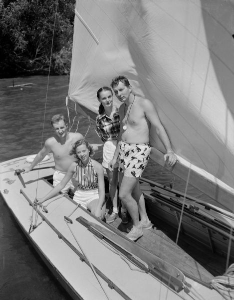 Outdoor group portrait of members of the crew of the sailboat <i>Seaspur</i>, winner of the Mendota Yacht Club's Fourth of July Handicap Race in 1952. Pictured left to right are: Mr. and Mrs. Ed Hobbins, and Dr. and Mrs. William B. Hobbins. Ed Hobbins is the skipper.