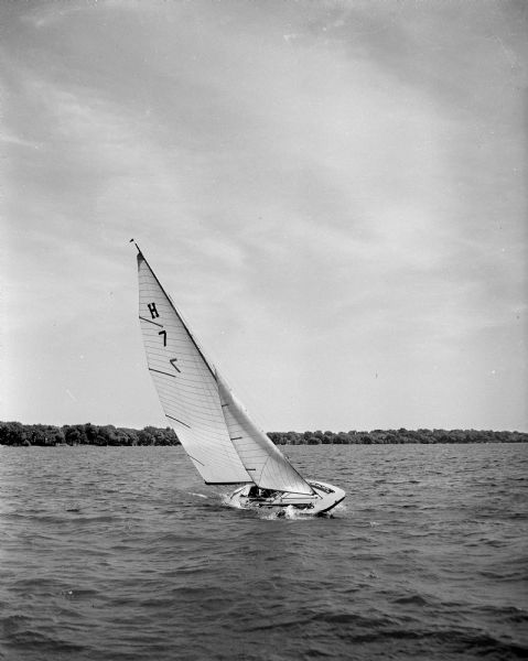 The Seaspur, a Class E sailboat, is shown under full sail on Lake Mendota. It was the winner in the 1952 Fourth of July Mendota Yacht Club Handicap race.