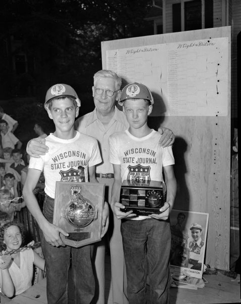 Ralph Hult, president of Hult's garage and the co-sponsor of the Madison Soap Box Derby, poses with the top winners. At left is champion Larry Laverty who holds the championship trophy. At right is Larry Tracy of Montfort, who holds the radio he won as the second prize.