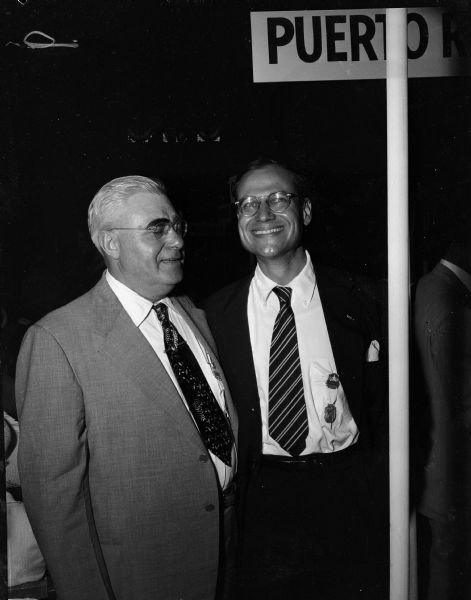 National Democratic Convention delegates Herman Jessen and Henry Reuss stand on the convention floor.  Reuss had been actively campaigning for months for the Senate seat held by Joseph R. McCarthy. He hoped to run unchallenged. However, shortly before the deadline, Thomas Fairchild also filed, and he was ultimately successful in the Democratic primary.  Jessen, a mink raiser from Phelps, was the party's candidate for secretary of state.