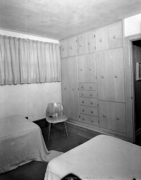 Interior view of the home of Mr. and Mrs. Don J. (Jean) Voegeli at 2805 Oxford Place in Shorewood Hills. The spacious one-story home was designed around the three young Voegeli children. The master bedroom, pictured here, features built-in birch cabinets, closets, and drawers so that the only furniture needed is two beds and several chairs.