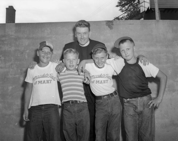 The Reverand Jerome Mersberger of the Immaculate Heart of Mary Parish is pictured standing behind the four boys who sold the greatest number of tickets for the sports show to be held at Breese Stevens Field. Left to right: Ronnie Larson, Dick Fernhoix, Wayne Dolphin, and Pete Fox.