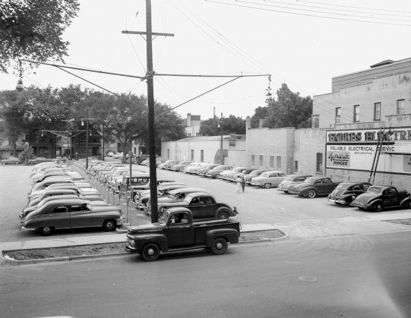 View of a filled parking lot at Block 53, 300 block of West Mifflin Street. The Endres Electric sign is visible.