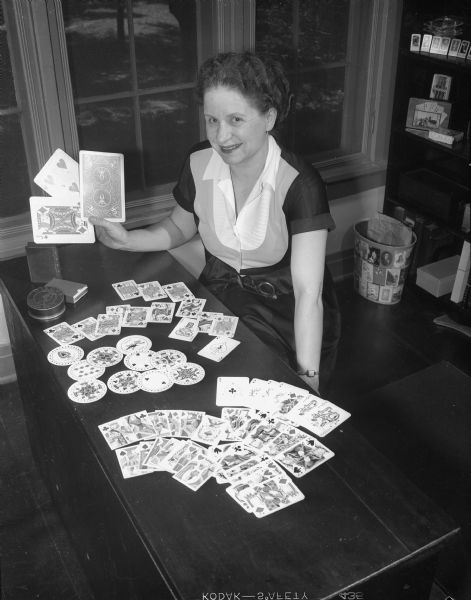 Mrs. Charles (Jeanette) Kincaid of 2122 Vilas Avenue is shown with a display of some of her playing card collection. Mrs. Kincaid has collected more than 400 decks of cards, one of the world's largest collections.