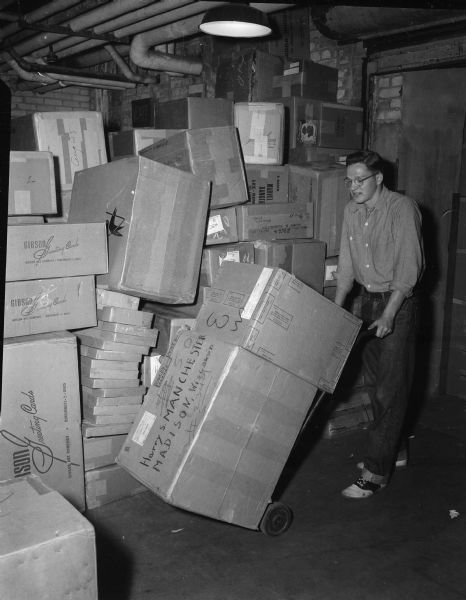 Jim Hursh of 2415 Norwood Place, a 1952 graduate of West High School, works at his summer job in the shipping room of an unspecified Madison department store.