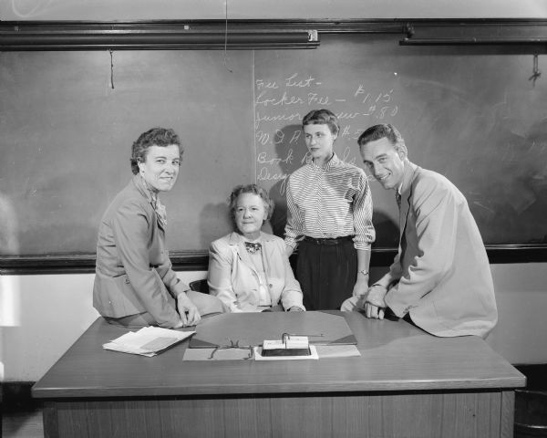 Four new teachers on the staff of Central High School gather around a desk in a classroom. From left to right: Miss Marguerite Wojta, mathematics; Miss Lucile Reid, modern languages; Miss Mildred Reider, English, and Donald Wendt, social studies.