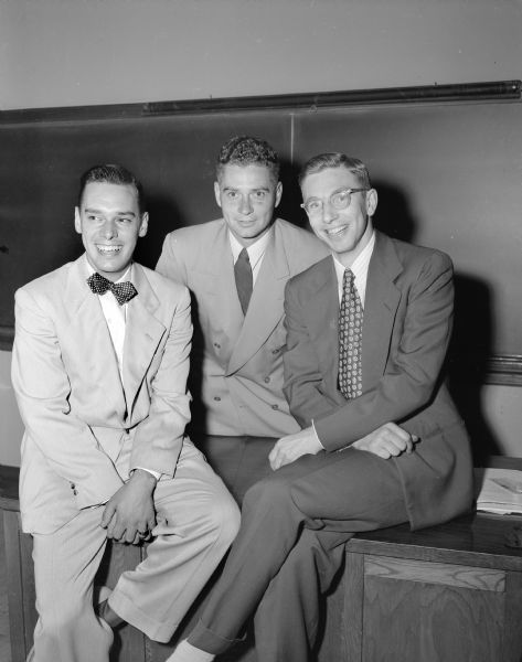 Three new teachers on the staff at West High School sit in a classroom. Left to right: Raymond Quant, English and social studies; William C. Struck, English and mathematics, and Willis Ehlert, English.