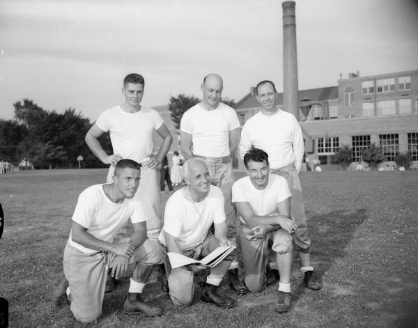 Group portrait of West High School coaching staff. Shown kneeling in the front row are: Al Trotalli, Coach Willis Jones, and Joe Antonie.  Shown standing in the back row are: Bill Struck, Dalton Hedlund, and Dale Wesenberg.