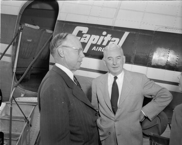Ohio Republican Senator Robert A. Taft and his convention floor manager, Madison's Thomas E. Coleman, are shown at Truax municipal airport standing by the doorway of Taft's chartered DC-3 Capitol Airline plane.