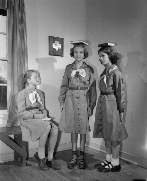 Practicing good posture for the personal health badge are three members of the Girl Scout troop at Lakewood School in Maple Bluff. Pictured left to right are: Sue Reynoldson, daughter of Mr. and Mrs. Jack Reynoldson; Mary Lee Sedgewick, daughter of Mr. and Mrs. Halsey Sedgwick; and Susan Brandt, daughter of Mr. and Mrs. Edward Brandt.