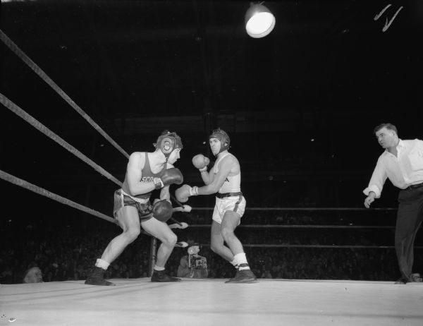 Action shot during the 149-pound semi-final match of the All UW Boxing Tournament. John Hobbins (left), Madison, and Bobby Goodsit of Milwaukee are sparring.