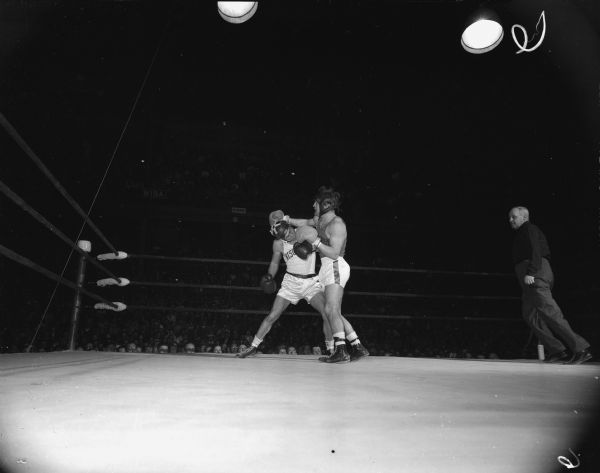 Charles Magestro, University of Wisconsin 139-pound boxer, in match with John Granger, Syracuse University boxer. Wisconsin beat Syracuse 6-2.  One of eighteen images.