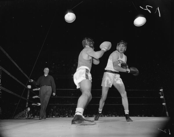 Action shot of the boxing match between the University of Wisconsin and the University of Syracuse.