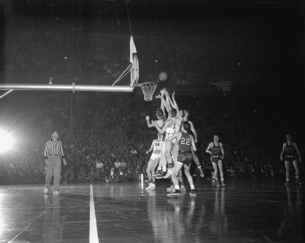 Four players, two each from Tomah and Sheboygan Central High Schools, battle for a rebound during the state boys' basketball tournament. Sheboygan defeated Tomah 68-60 to go on into the semi-final round.