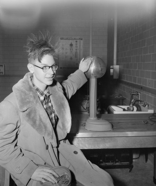 Jack Botteron, Beloit high school student, touches a small Van de Graaff generator which causes his hair to stand on end while attending the UW Engineering Expo.