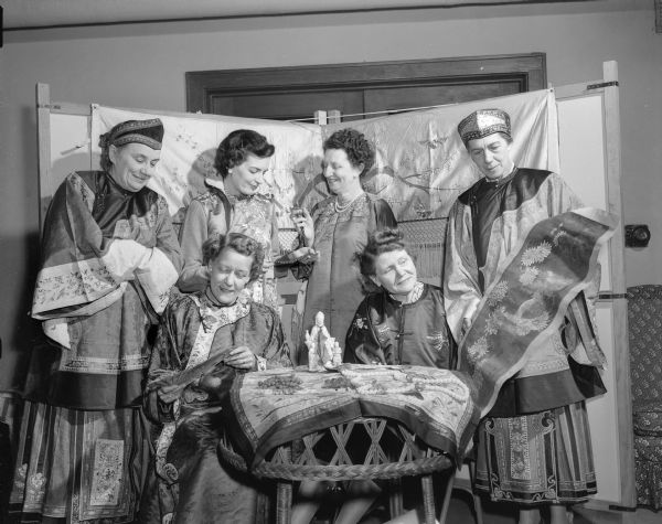 Group portrait of six members of the St. Andrew's Women's Guild dressed in Chinese costumes to promote an upcoming Chinese Festival at the church. The costumes are owned by Eunice Burns, whose parents were medical missionaries in China. Left to right: Bertha Stiles, Annetta King, Gladys Buck, Margaret Trotter, Eunice Burns and Mrs. R.T. Walker.