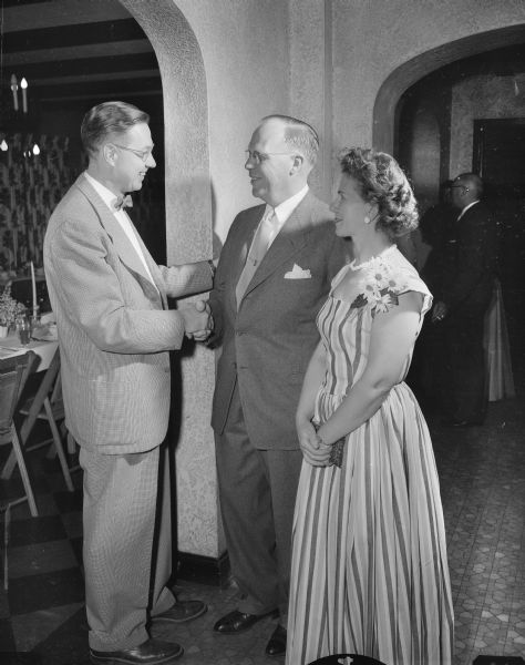 Louis Busse, one of the new members of the Cosmos Dance Club, is greeted by Victor and Stella Johnson at the club's 30th anniversary dinner dance held at the Nakoma Country Club.
