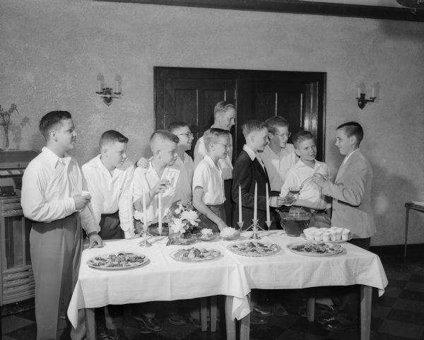 Ten boys of the Nakoma School 8th grade graduating class gather at the refreshment table during a party at the Nakoma Country Club.  Left to right:  Kent Kildow, Phil Little, Bill Whitford, Warren Comstock, Jim Rasmussen, Tim Trowbridge, John Stephens, Ted Odell, Dick Wegner and Gregory Brown.