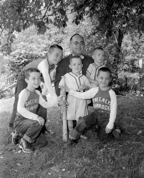 A photographic tribute to Madison dads on Fathers' Day includes a photograph of Raymond P. Sweeney and his five sons dressed in baseball uniforms. Pictured are Jack Sweeney, Tim Sweeney, Mike Sweeney, Greg Sweeney, and Danny Sweeney. Raymond P. Sweeney is the Vice-President and Secretary of Automatic Temperature Supplies.