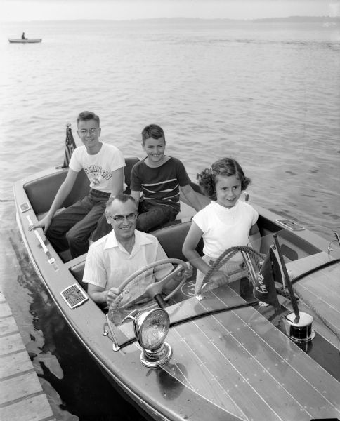 A photographic tribute to Madison dads on Father's Day includes a photograph of Dr. Cyrus Reznichek, a physician, and his three children, Dick Reznichek, Bob Reznichek, and Joan Reznichek in their motorboat.