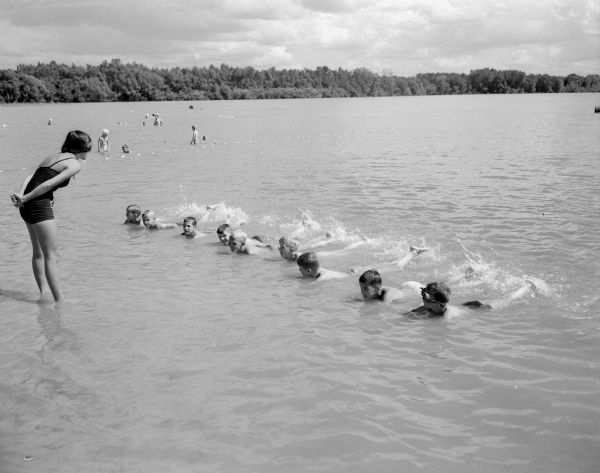 Sally Smith directs a group of beginning boy swimmers during swimming lessons at Lake Wingra.
