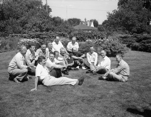 Group portrait of members of Frank Horner's Sunday school class, seated on the lawn at the Horner home at 3515 Blackhawk Drive, who returned for a reunion. Horner taught the class for 16 years (1920-1936) at the First Baptist Church. Seated in back, left to right, are: Kenneth Kimball, Robert Larson, Herbert Harris, Elmer MacMurray, Prof. William Bascom, and Stanley Otis. Seated in front are: Reginald Price, Russell Coster, George Kelly, Charles Otis, Dr. John Mendenhall, John White, Robert Blau, and Frank Horner.