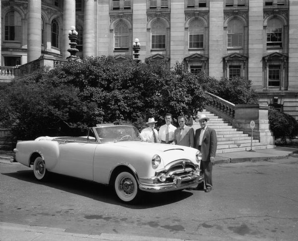 Four men and "the Caribbean," a new Packard convertible automobile, parked in front of the Wisconsin State Capitol building.