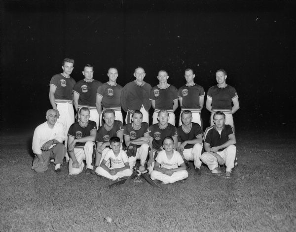 Group portrait of Frankie's Tavern softball team in uniform, with the team manager and bat boys.