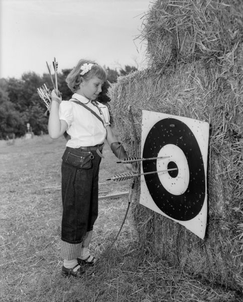 Lois Herning, age 10, surveys her results on an archery target at Blackhawk Bowhunters Club.