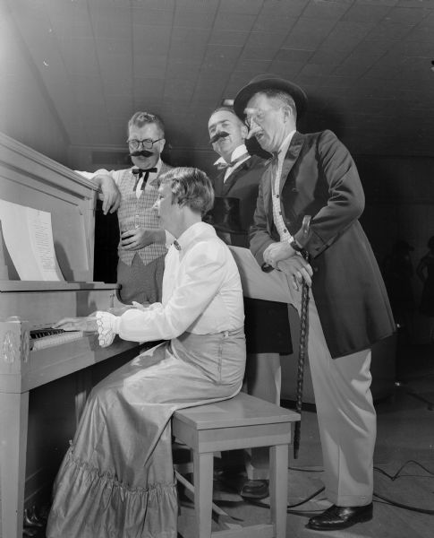 Musical entertainment at the Blackhawk Country Club Gay 90's party.  Helen Nichols is accompanying a trio on the piano. Singers are, left to right: Dr. L.R. McCormick. Howard Radder, and George Nichols.