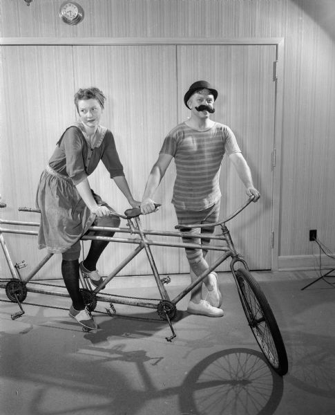 Stanley and Florence Herrling posing on a bicycle built for four at the Blackhawk Country Club Gay 90's party.