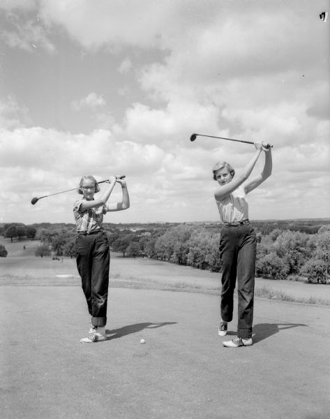 Barbara Detloff and Pat Taplich practice 'following through' during their golf lessons.